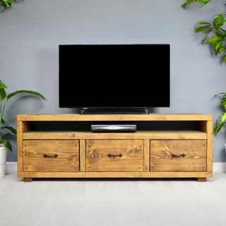 Solid wood tv unit in a medium oak finish, featuring 3 drawers with black metal handles in a chunky rustic style. Handcrafted in the New Forest.