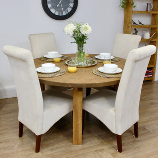 The Dalstan round dining table embodies modern rustic charm, handcrafted from solid wood for durability and character. This bespoke farmhouse table offers customizations in length, width, style, color, and finish, ensuring it fits seamlessly into any cottage or farmhouse kitchen.