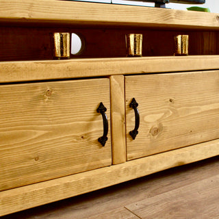 The Hale TV unit, a rustic corner TV cabinet handmade in the New Forest, showcases storage with charming rustic wooden doors.