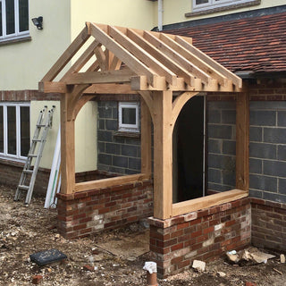 Solid Oak Ivy Porch Kit: Crafted from green oak, featuring mortice and tenon joints and hand-cut rafters. Comes pre-drilled with pegs, half lap joints, and finished with linseed oil for natural grain enhancement.