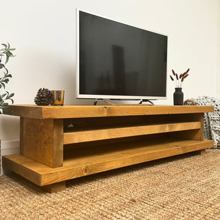 Introducing the Ashlett TV unit, a handmade rustic entertainment unit crafted for your living room. Made from solid wood, this bespoke console unit features a shelf for storage, offering functionality and style.