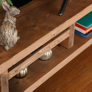 A close view of the Blissford TV unit reveals its rustic style and solid wood construction. Handmade using traditional carpentry methods, this TV media unit, pictured in dark oak, enhances natural knots and wood grain, adding character to your furniture.
