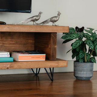 Close view of the open shelf on the Blissford TV unit, handmade in the New Forest. Featuring black hairpin legs and crafted from natural wood, this piece offers both storage and style for your living room furniture.