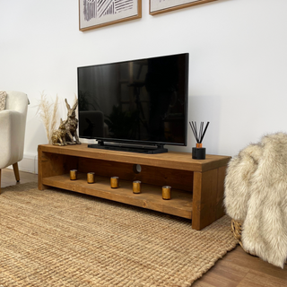 The Woodside TV unit is a rustic handmade entertainment unit designed to enhance your living room. Crafted from solid wood, this console unit features a shelf for storage, providing functionality for your TV media needs.