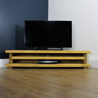Elevate your living room with the Holbury TV unit, a rustic wooden entertainment unit designed to add both style and functionality to your space. Crafted from solid wood, this corner TV unit features a shelf for storage.