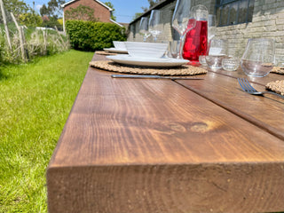 The Harlow Handcrafted Reclaimed Wooden Garden Dining Table. A rustic outdoor centerpiece, crafted from reclaimed wood for timeless charm.
