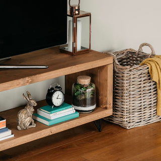 Our Romsey Tv unit is a rustic wooden entertainment unit designed to elevate your living room decor. Crafted from solid wood, this handmade console unit features a shelf for storage, offering functionality and style.