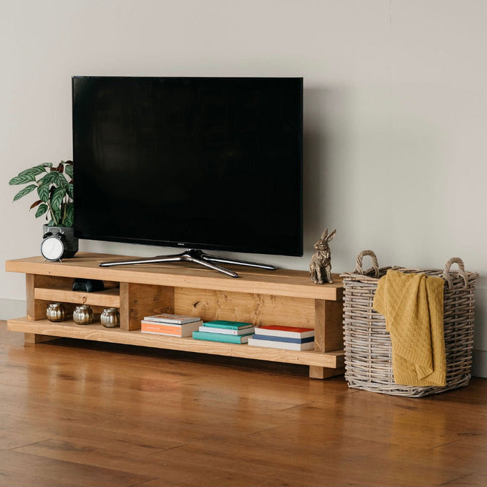 Solid wood extra wide tv unit in medium oak stain, featuring a shelf for added storage, in a chunky rustic style. Handcrafted in the New Forest.