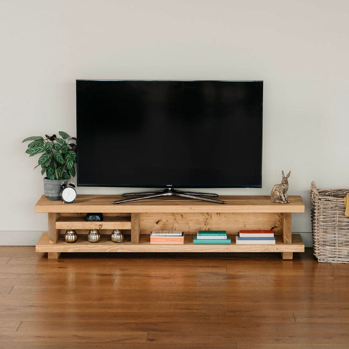 Solid wood extra wide tv unit in medium oak stain, featuring a shelf for added storage, in a chunky rustic style. Handcrafted in the New Forest.