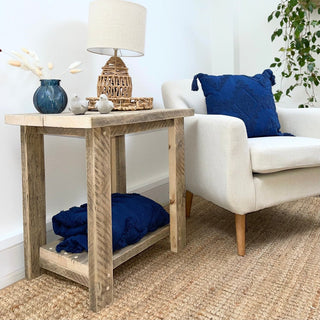 The Ryde side table brings rustic charm to your living room, crafted from solid wood. This farmhouse-inspired wooden table adds a touch of modern farmhouse style to any cottage or living room decor. With its natural wood finish, it's the perfect addition to your rustic furniture collection.