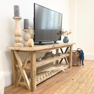 Introducing the Winford Solid Wood Reclaimed TV Unit with Storage: Handmade in Hampshire, this bespoke centerpiece combines vintage allure with modern functionality, featuring a unique cross design and ample storage for your audio equipment.